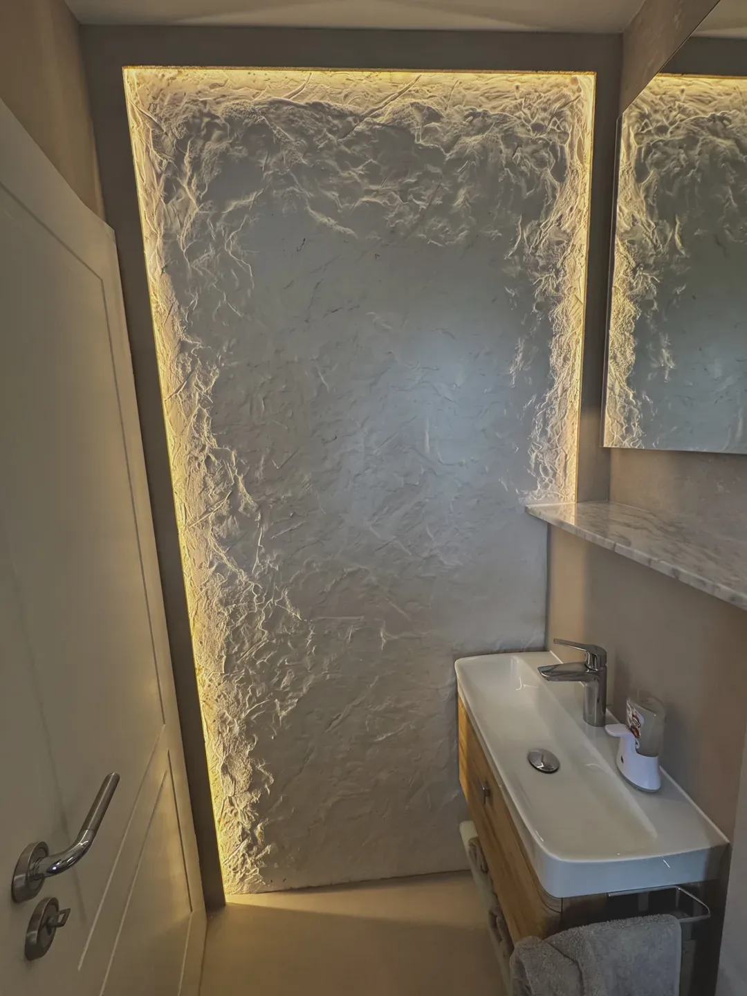 Badezimmer mit strukturierter Wandfläche und indirektem Licht – Malerbetrieb Mergenthaler im Saarland